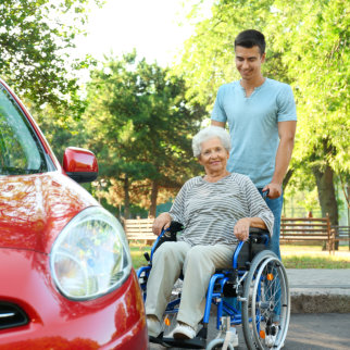 man pushing elderly in a wheelchair