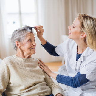 caregiver combing elderly woman's hair