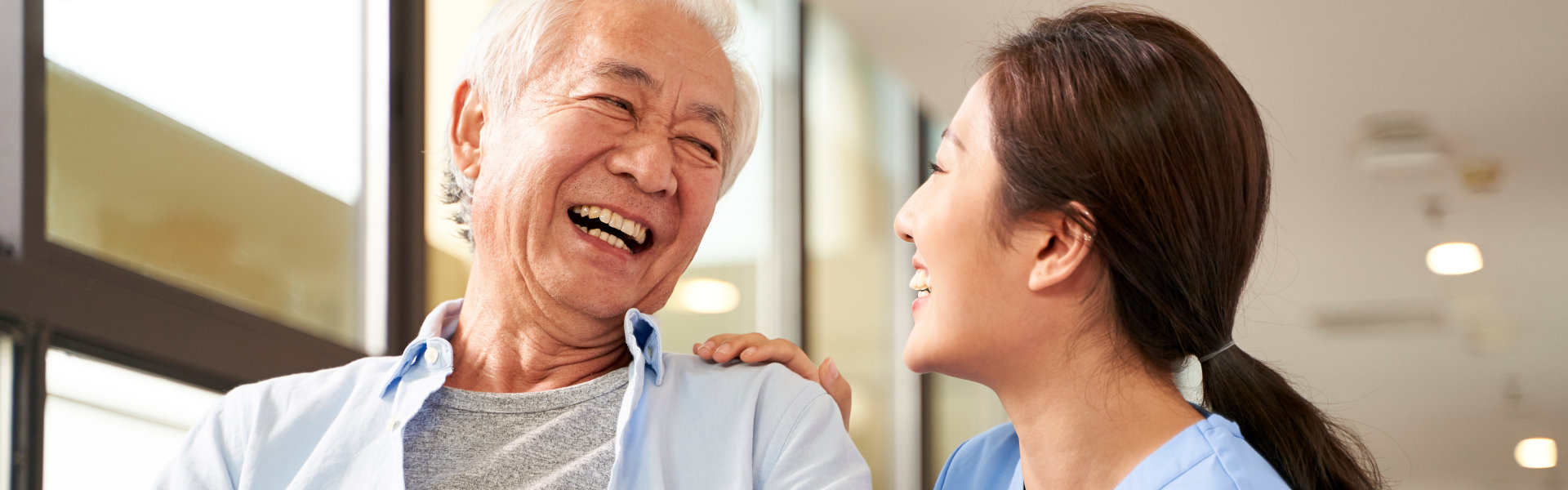 patient and his caregiver smile at each other